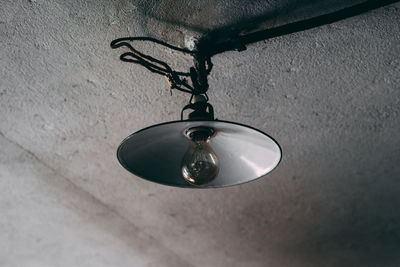 Low angle view of light bulb hanging on ceiling