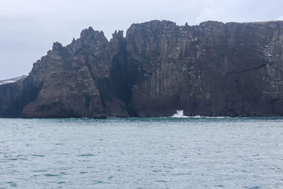 Scenic view of sea and mountains against sky