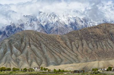 Scenic view of snowcapped mountains against cloudy sky