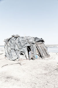 Abandoned umbrella on beach against clear sky