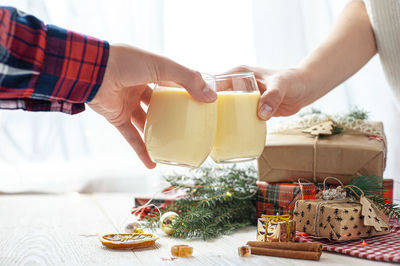 Two glasses with eggnog in hand. christmas dessert. sweet winter cocktail selective focus