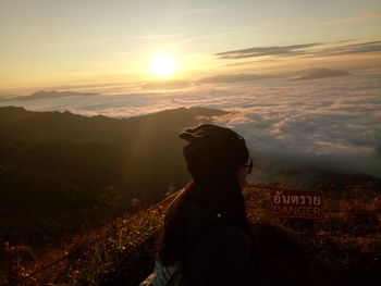 Silhouette woman standing on mountain against sky during sunset