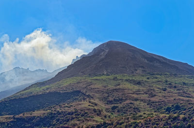 Scenic view of mountains against blue sky