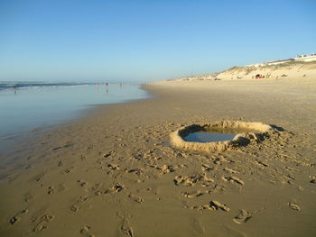 Scenic view of beach against clear sky