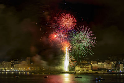 Firework display over river at night