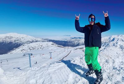 Full length of man standing on snow covered mountain