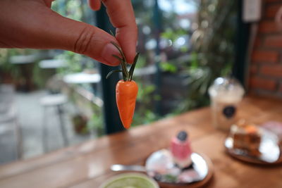 Close-up of person holding food on table