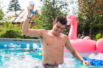 Full length of shirtless man in swimming pool