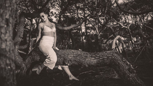 Full length of woman with arms raised in forest
