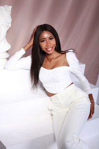 Young woman sitting on bed at home