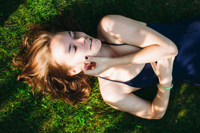 High angle view of woman in bodysuit lying on field