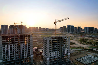 Modern buildings in city against sky during sunset