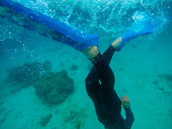 Low section of man swimming in sea