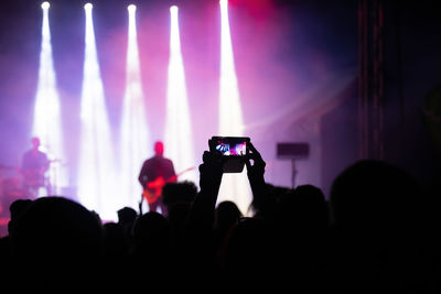 People photographing at music concert