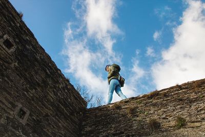 Low angle view of man standing against blue sky