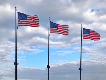 Low angle view of flag flags against sky