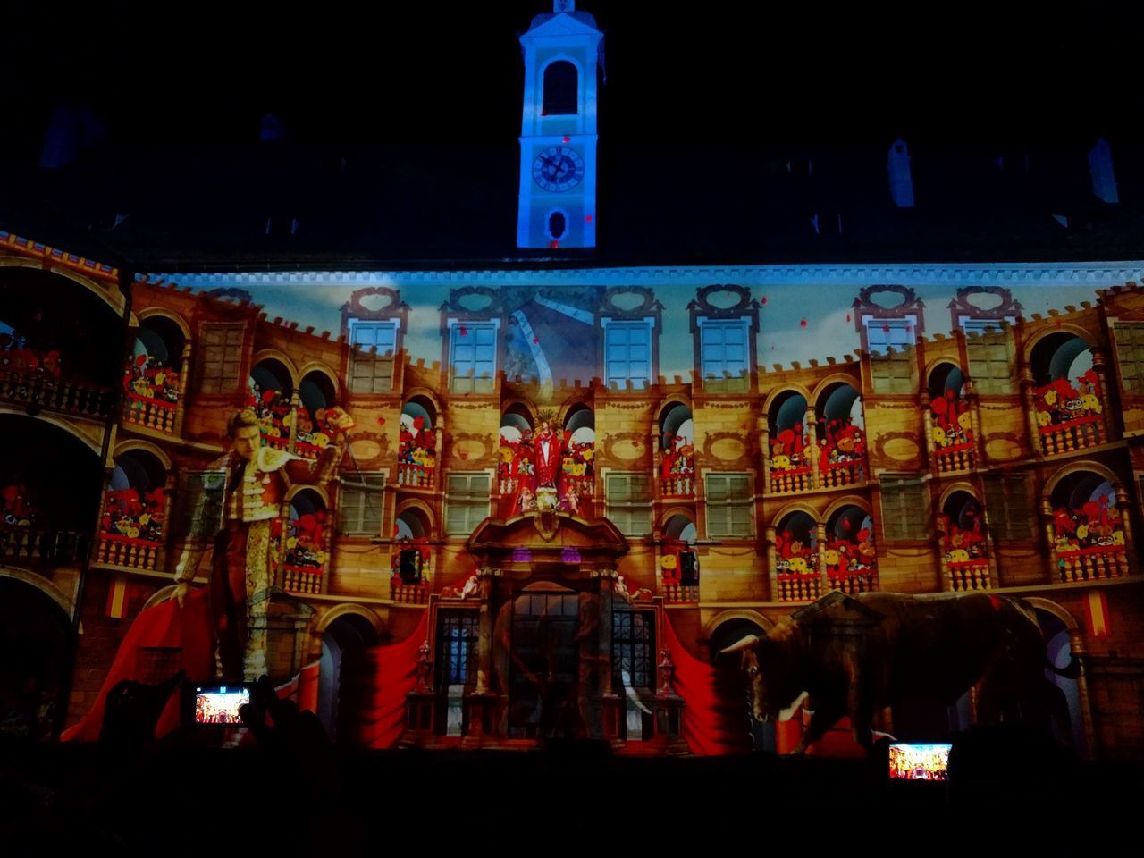 LOW ANGLE VIEW OF ILLUMINATED STATUE AGAINST BUILDING