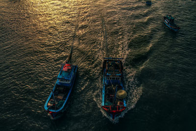 High angle view of boats sailing in sea during sunset