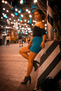 Full length of woman at illuminated city at night