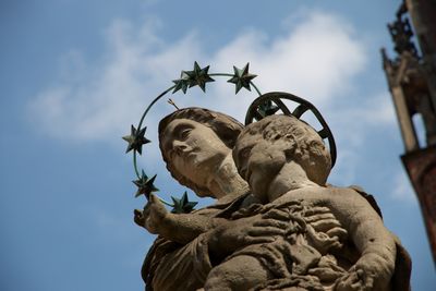 Low angle view of virgin mary statue against sky