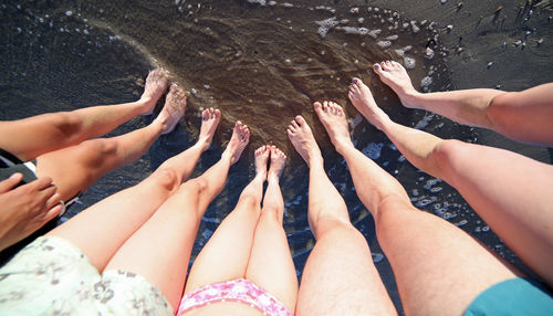 Low section of people feet in water
