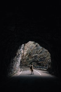 Rear view of man walking in tunnel