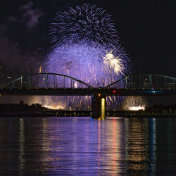 Firework display over river at night