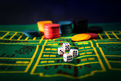 Close-up of gambling chips and dices on table at casino