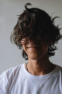 Close-up portrait of young man standing against wall