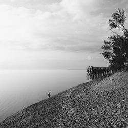 Pier on sea against cloudy sky