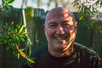 Portrait of smiling man against plant