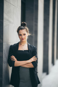 Portrait of woman standing against wall