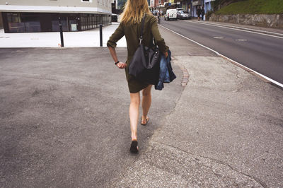 High angle view of young woman standing on footpath