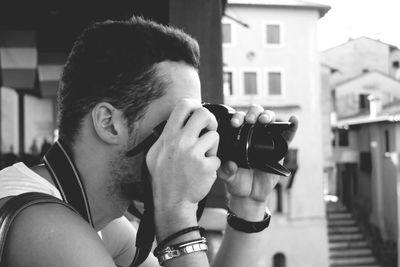 Side view of photographer photographing in city