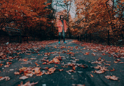 Full length of man standing on road during autumn