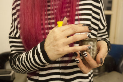 Midsection of woman holding container