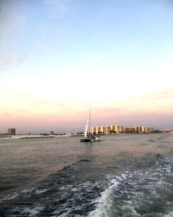 Sailboat in sea against sky during sunset