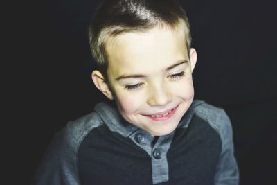 Close-up of cute boy against black background