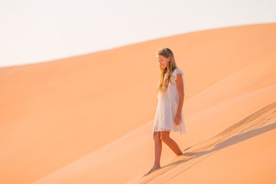 Woman standing on sand dune in desert