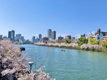 Panoramic view of buildings in city against clear blue sky