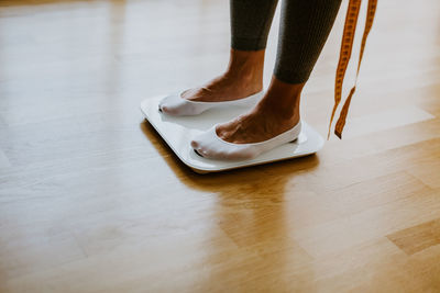 Low section of woman standing on wooden floor