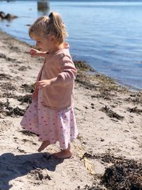 Side view of girl walking on shore at beach