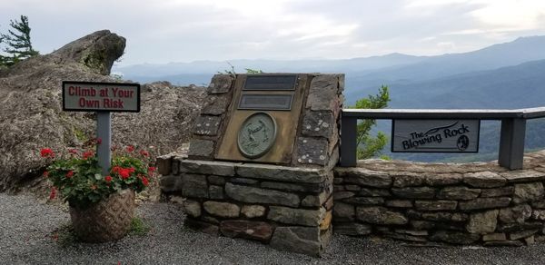 Information sign on mountain against sky