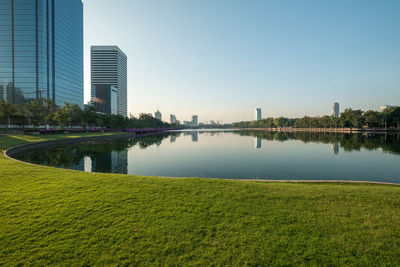 Scenic view of lake and buildings against clear sky