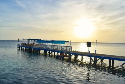 Pier on sea against sky during sunset