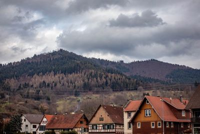 Houses against buildings and mountains against sky