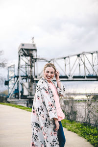 Woman standing on bridge against sky