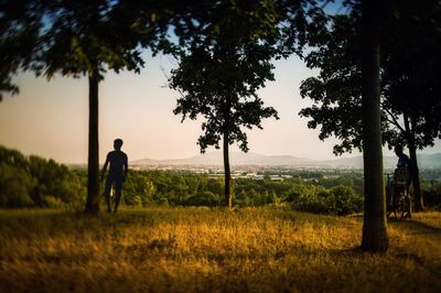 Silhouette man on field against sky at sunset