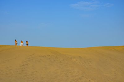 Scenic view of desert against clear blue sky