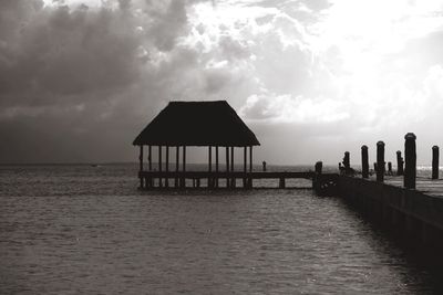 Silhouette pier on sea against sky